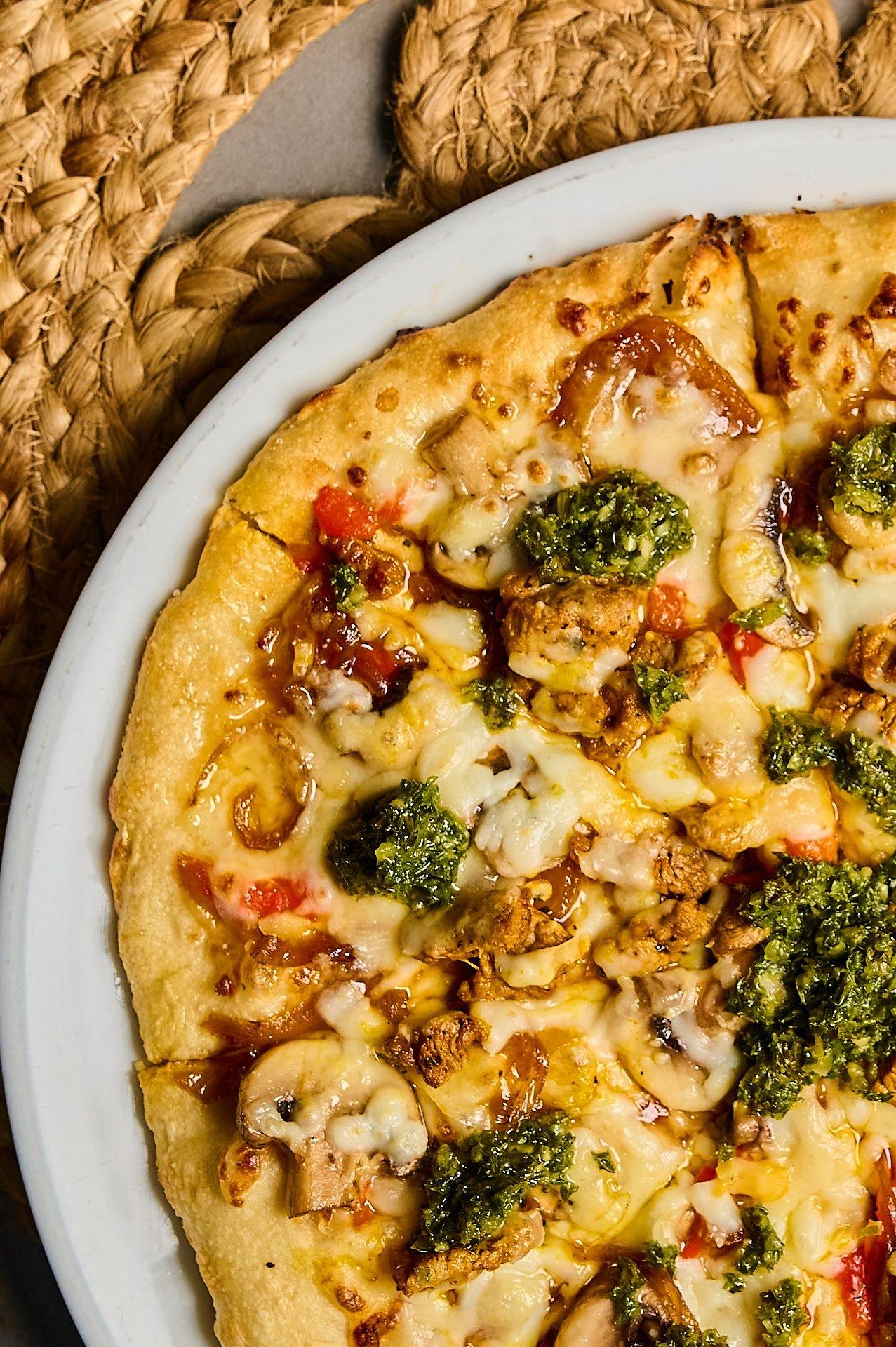 Pizza artesanal con vegetales y queso fundido en mesa de piedra