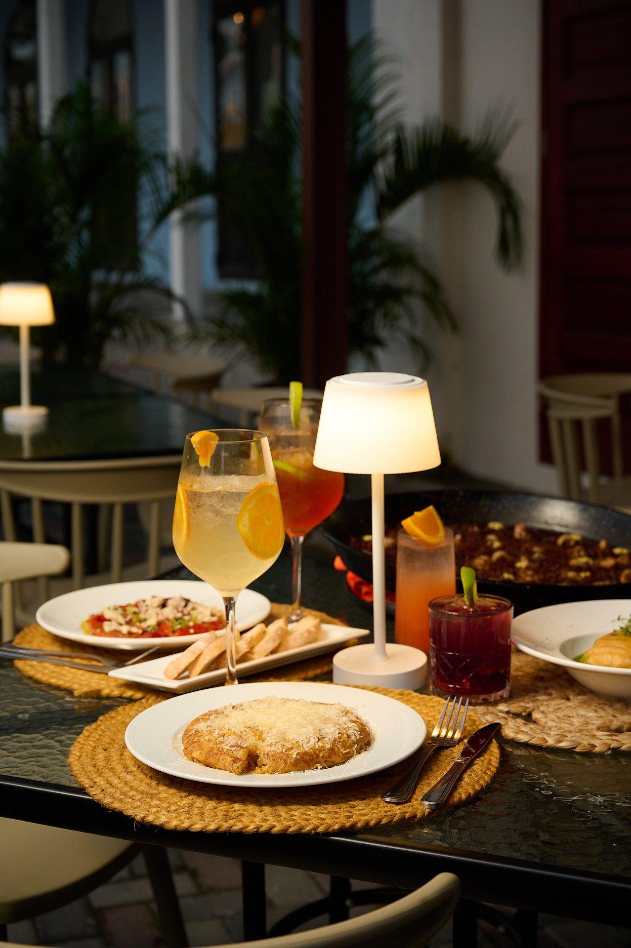 Terraza de Santa Rita de noche con lámparas de mesa encendidas