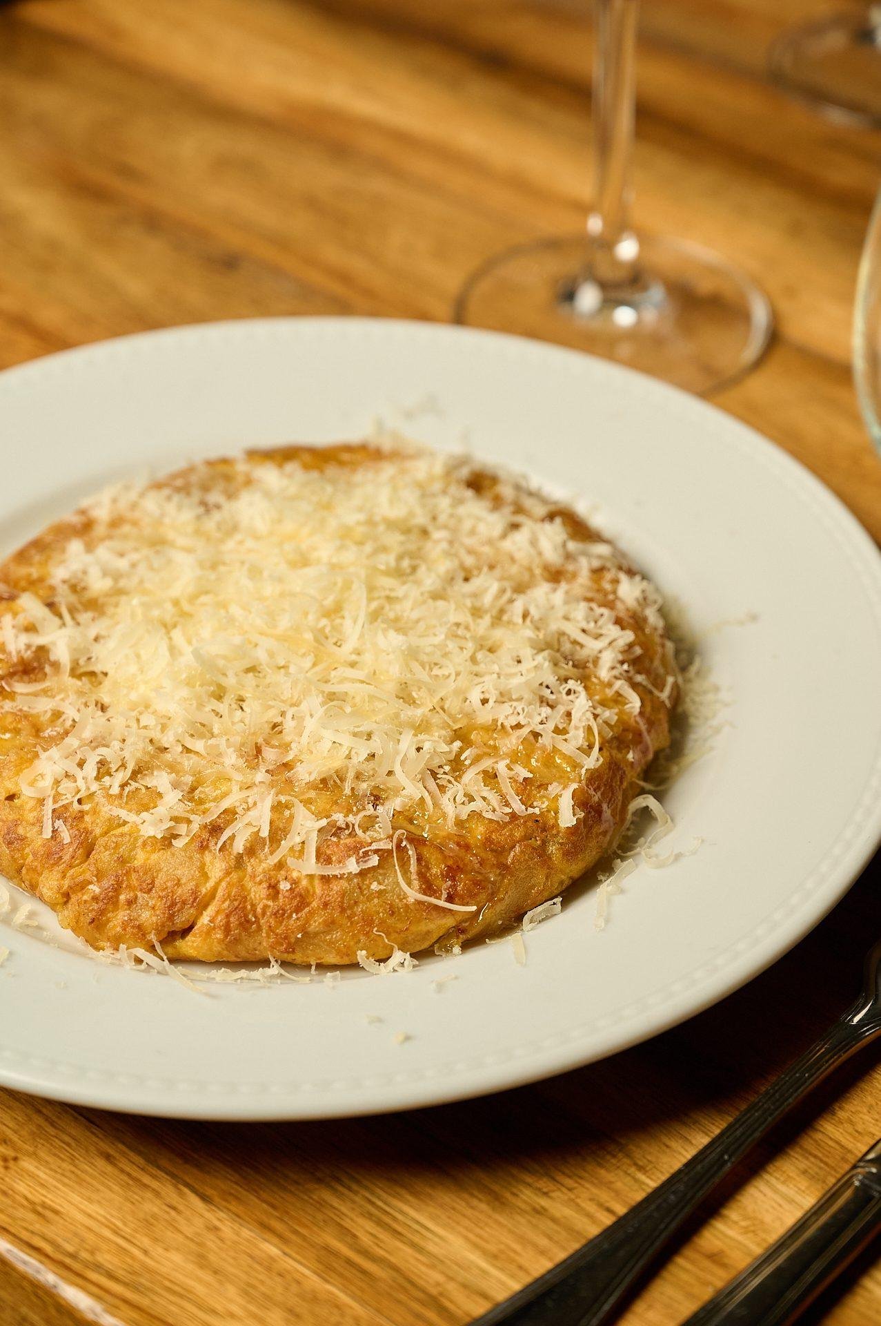 Tortilla española gratinada con queso rallado al momento